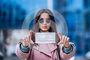 Female in medical mask outdoors in the empty city. Health protection and prevention of virus outbreak, coronavirus, COVID-19,