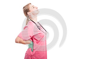 Female medical nurse holding her back like hurting