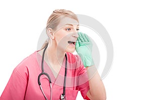 Female medical nurse wearing scrubs yelling out loud