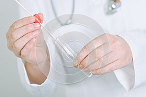 Female medical specialist holding buccal cotton swab and test tu photo