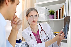 Female medicine doctor explains to male patient diagnosis