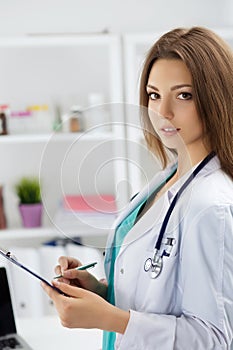 Female medicine doctor filling in patient medical history