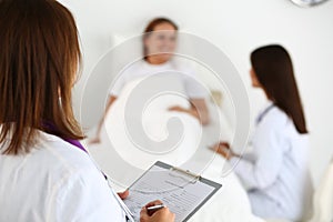 Female medicine doctor filling in patient medical history list d