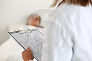 Female medicine doctor filling in patient medical history list d