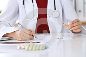 Female medicine doctor fills up prescription form to patient closeup. Panacea and life save, prescribe treatment, lega