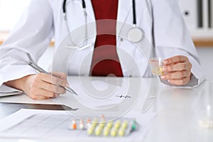 Female medicine doctor fills up prescription form to patient closeup. Panacea and life save, prescribe treatment, lega