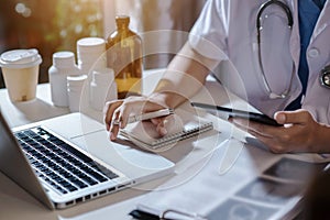 Female medicine doctor hand holding silver pen writing something on clipboard closeup.