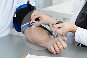 Female medicine doctor measuring blood pressure to patient