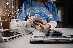 Female medicine doctor, physician or practitioner in lab room writing on blank notebook and work on laptop computer.