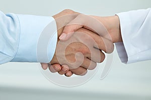 Female medicine doctor shaking hands with male patient