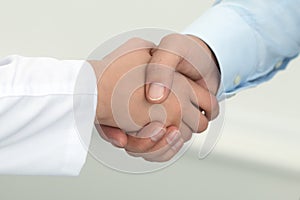 Female medicine doctor shaking hands with male patient.