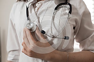 Female medicine therapeutist doctor hands holding stethoscope on