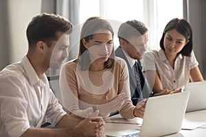 Female mentor help male intern explain online strategy on laptop