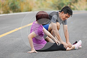 Female middle aged having a cramp while jogging