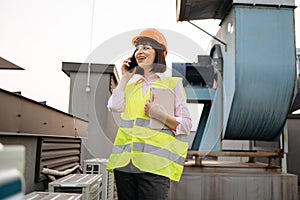 Female with mobile and tablet checking factory equipment