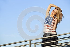 Female model on the background of sky in a t-shirt with the Amer