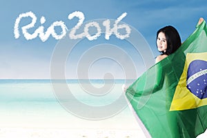 Female model with Brazilian flag at coast