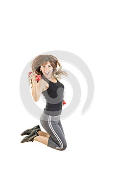 Female model in jump flexing and showing muscles with weights