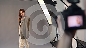 A female model poses for a male photographer.