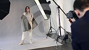 A female model poses for a male photographer.