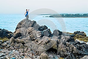 Female model posing on a beach with rocks