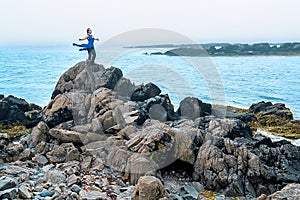 Female model posing on a beach with rocks