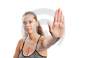 Female model in sportswear making stay away gesture with palm