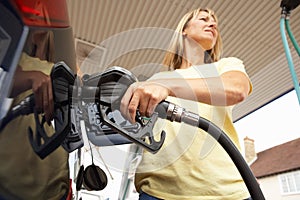Female Motorist Filling Car With Petrol At Petrol