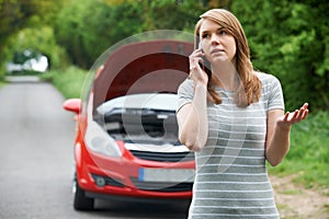 Female Motorist Phoning For Help After Breakdown