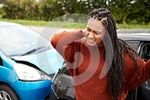 Female Motorist With Whiplash Injury In Car Crash Getting Out Of Vehicle photo