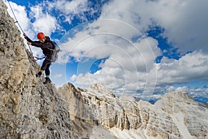 Female mountain climber on a steep Via Ferrata in the Italian Dolomites