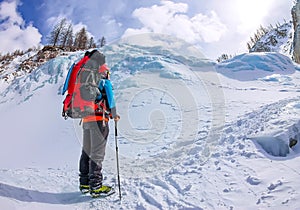 Female mountaineer with backpack, helmet and harness with climbing in mountain