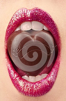 Female mouth with chocolate candy