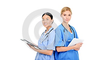 female multiethnic surgeons with clipboard and digital tablet,