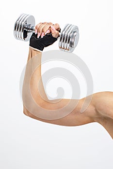 Female muscular arm with pink manicure holding steel dumbbell