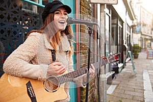 Žena hudobník akustická gitara a spev vonku v ulice 