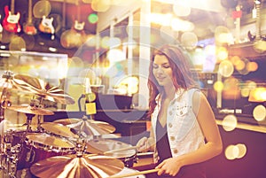 Female musician playing drum kit at music store