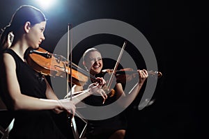 Female musicians playing on violins on