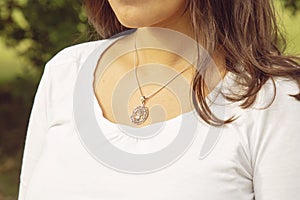 Female neckline wearing tiny silver chain with silver pendant