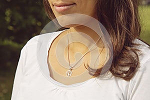 Female neckline wearing tiny silver chain with silver pendant