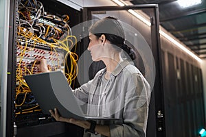 Female Network Technician Connecting Cables