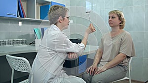 Female neurologist performing neurological tests on a female patient in an office