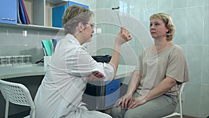 Female neurologist performing neurological tests on a female patient in an office