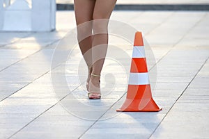 Female nude legs next to a reflective standing sign