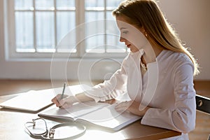 Female nurse busy filling medical history in journal