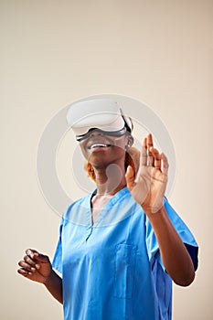 Female Nurse Or Doctor In Scrubs With VR Headset Interacting With AR Technology 