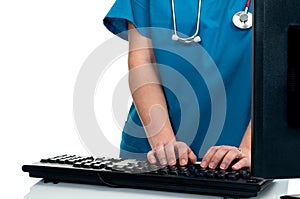 A female nurse/doctor standing to enter data