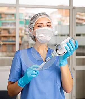 Female nurse or doctor wearing in face mask and medical uniform