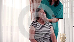 Female nurse giving head massage to senior woman at home