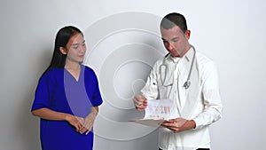 A Female Nurse Giving Her Report to a Doctor Who Checking it After